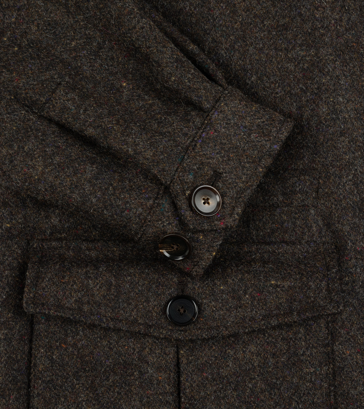 Close-up of the Caruso Shetland Wool Paddock Jacket Dark Brown showing the fabric texture, a buttoned cuff, and front flap pockets with dark buttons.
