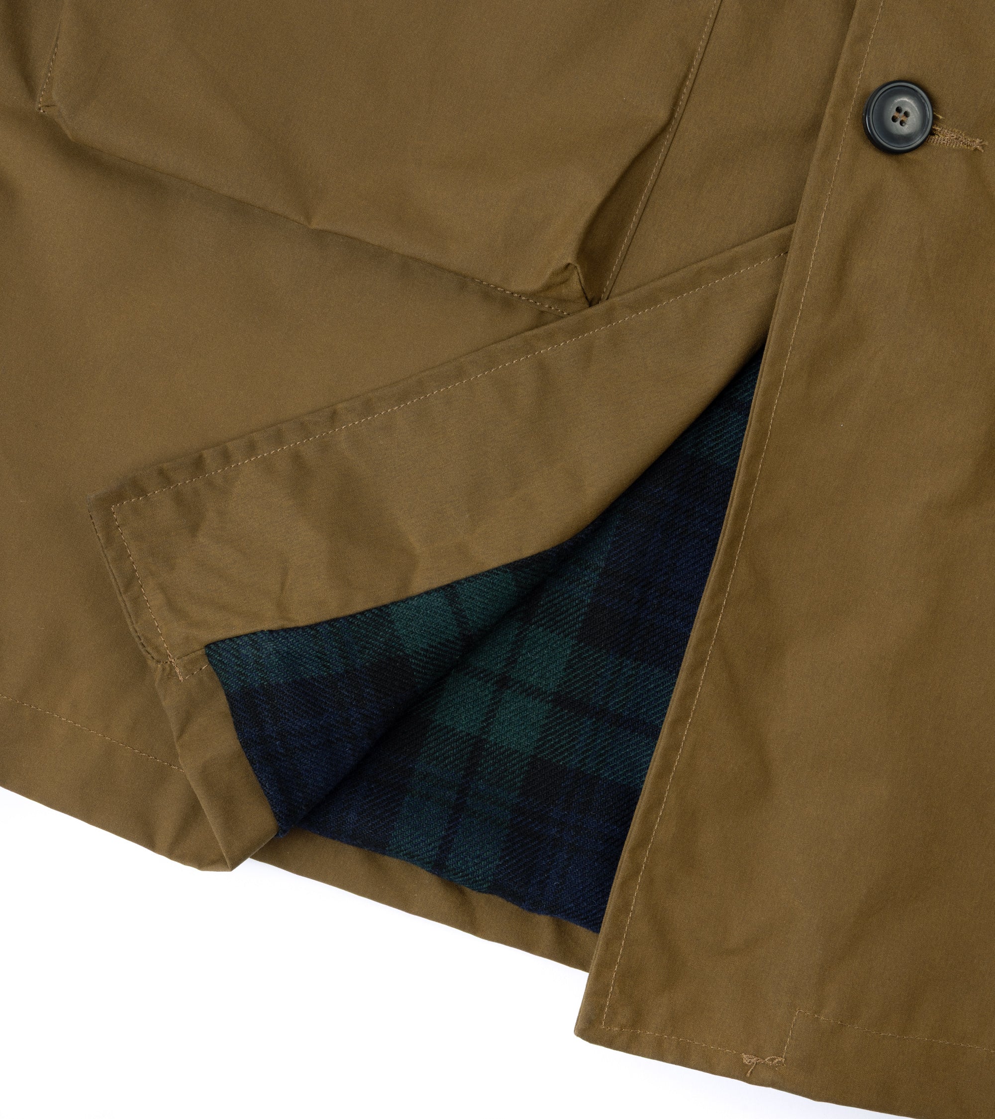 Close-up of a khaki jacket with a dark navy and green plaid lining visible along a folded cuff, featuring a dark button and clean white background.