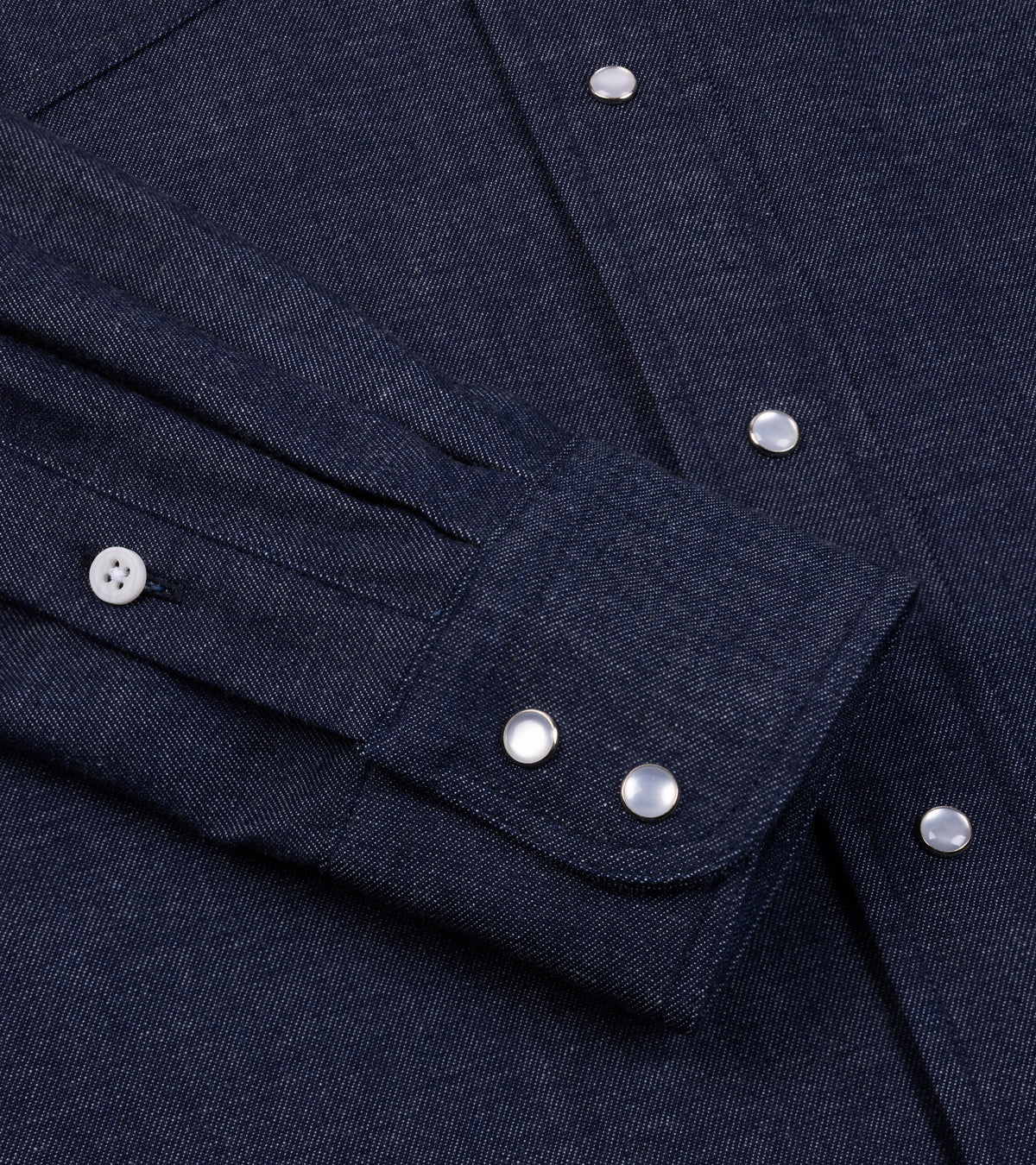 Close-up of the Gitman Vintage Denim Western Shirt in Dark Blue showing the cuff with western snap buttons and the fabric texture.