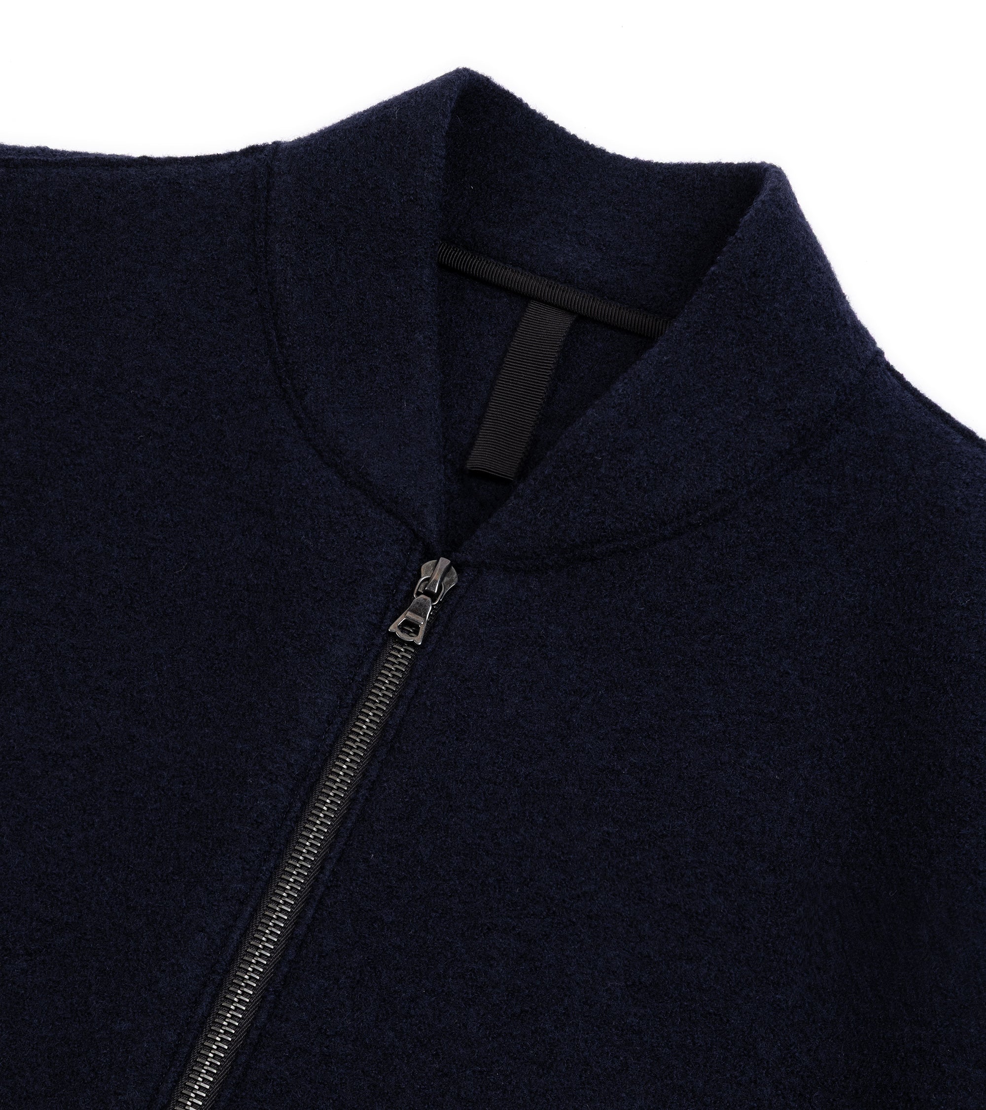 A close-up of a zip-up jacket featuring a high collar, a silver zipper.