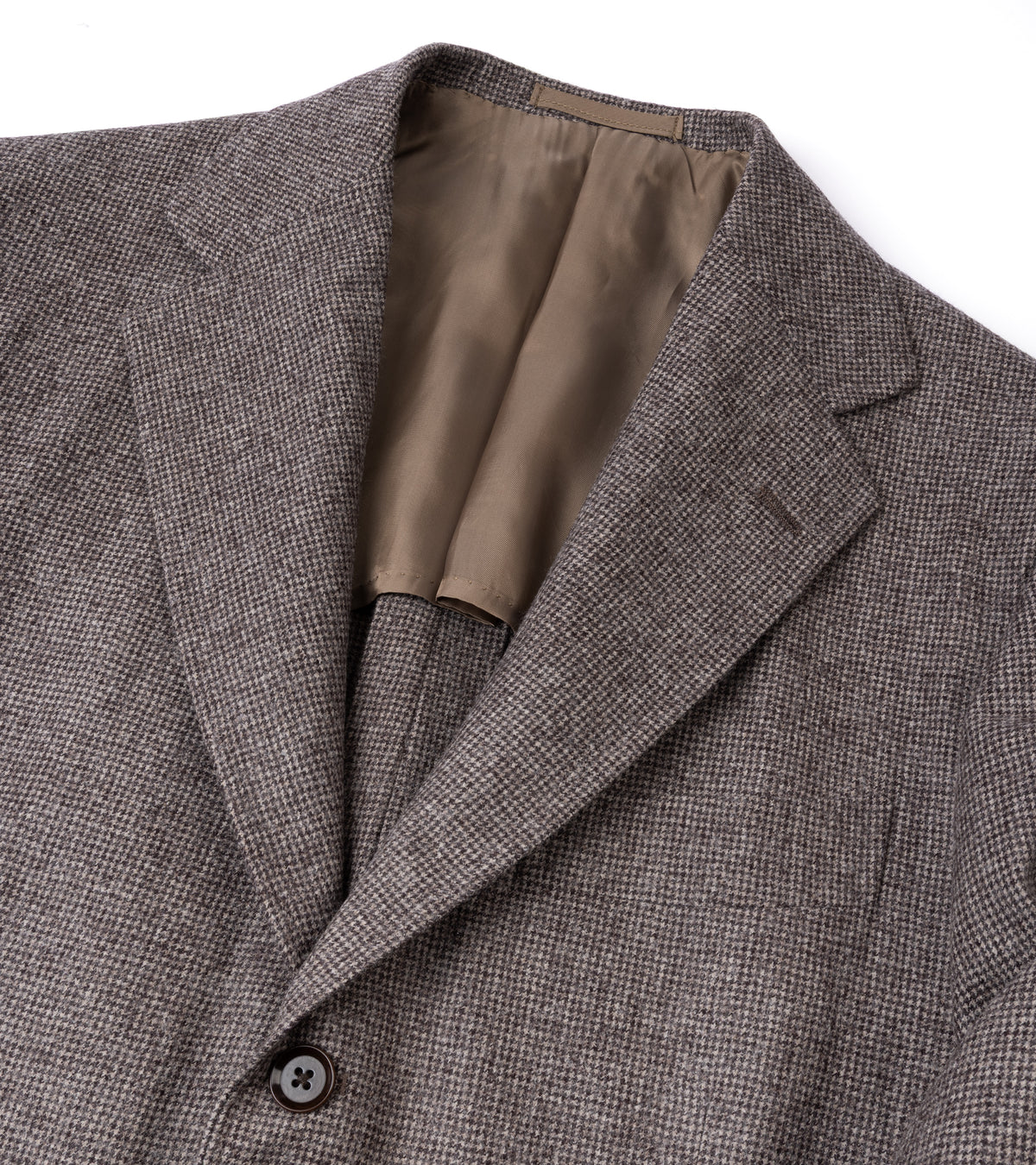 Close-up of a textured gray and brown herringbone blazer showing the collar, lapels, and inner lining against a white background.