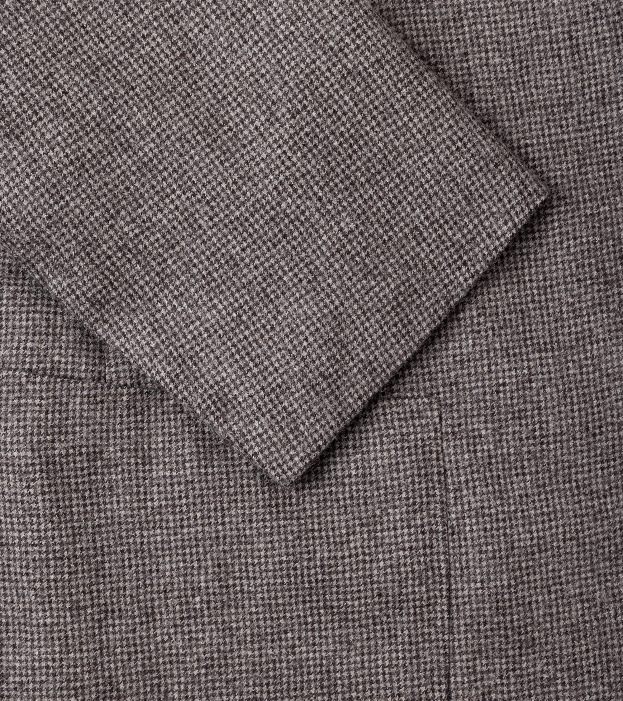 Close-up of a textured woven fabric in a grey brown color, showing the material detail and fold.