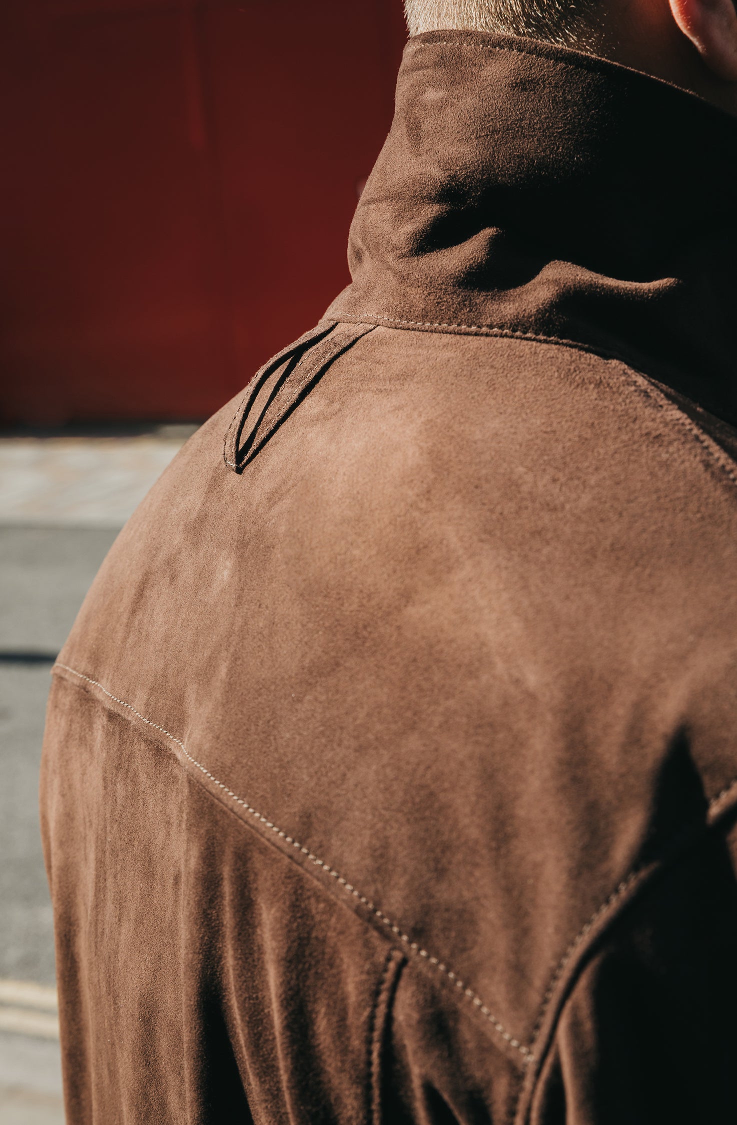 Brown jacket with a focus on the back, worn by a person.