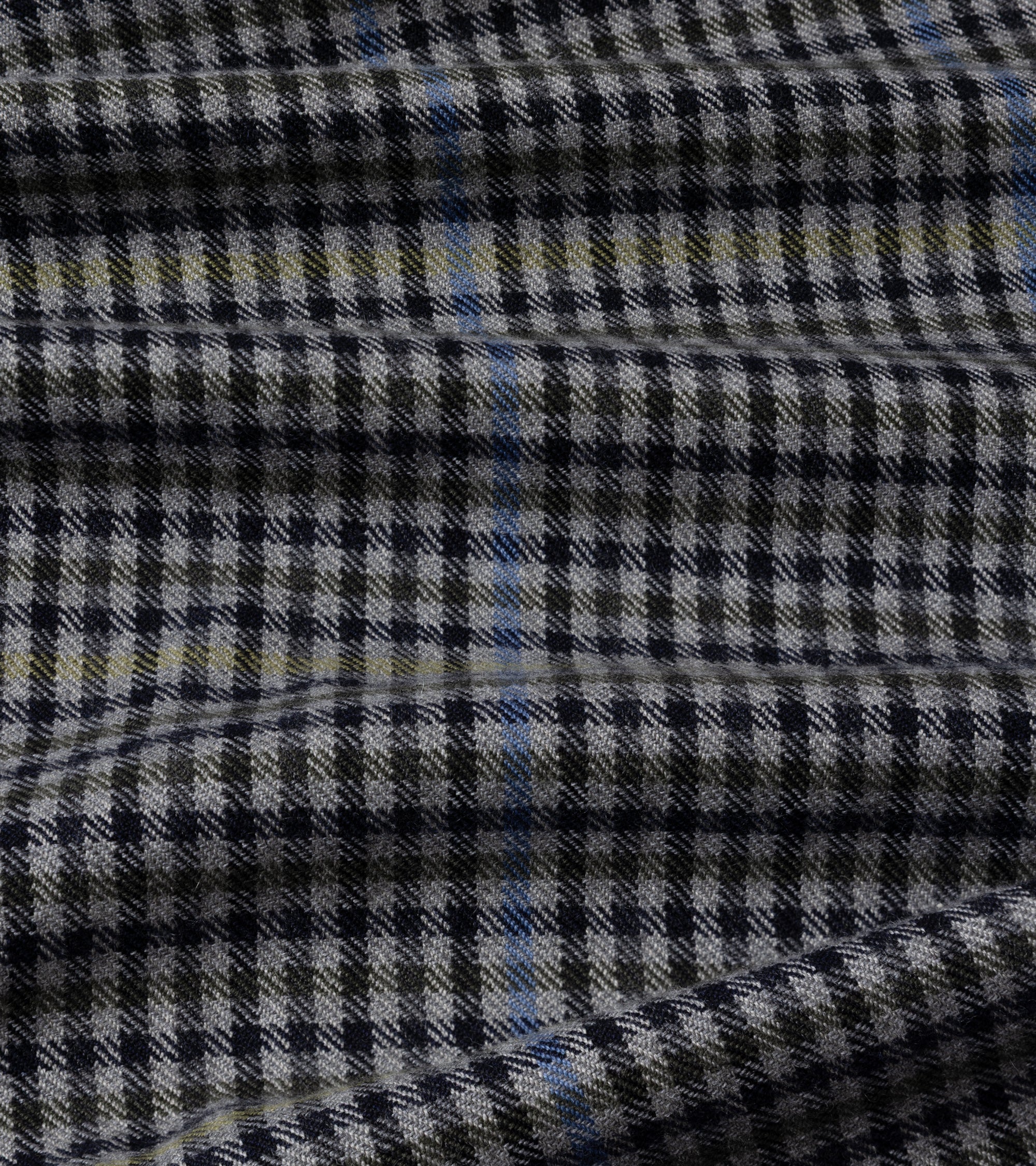 A close-up of a woven fabric with a black and grey houndstooth pattern, accented by thin blue and yellow stripes.
