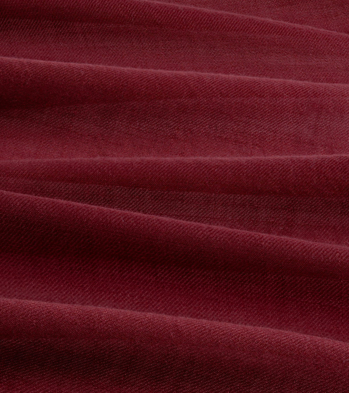 A close-up of the Begg x Co Wispy Solid Square Cashmere Scarf in Burgundy showing the fabric texture.
