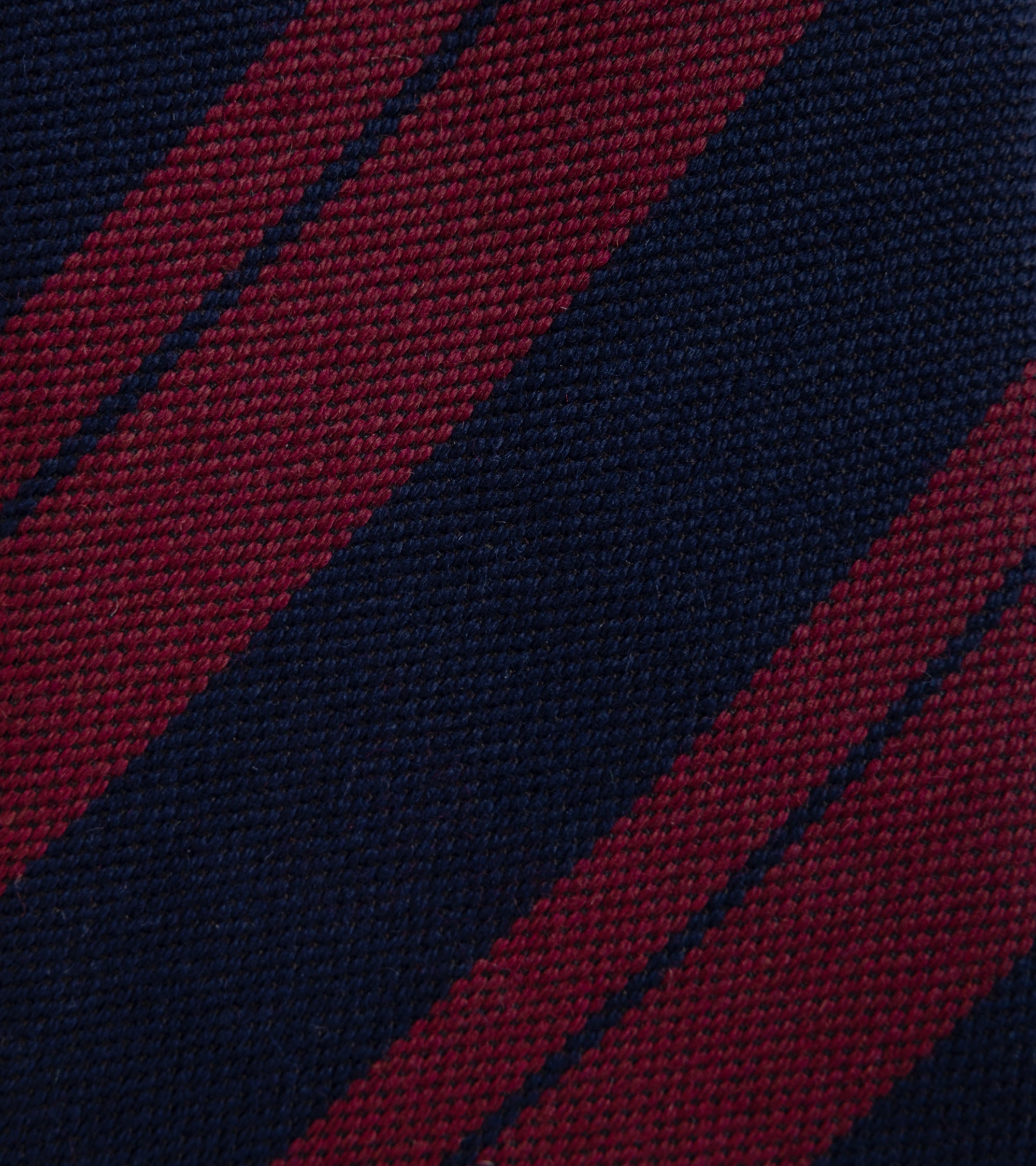 Close-up of a woven fabric with diagonal stripes in navy and burgundy.