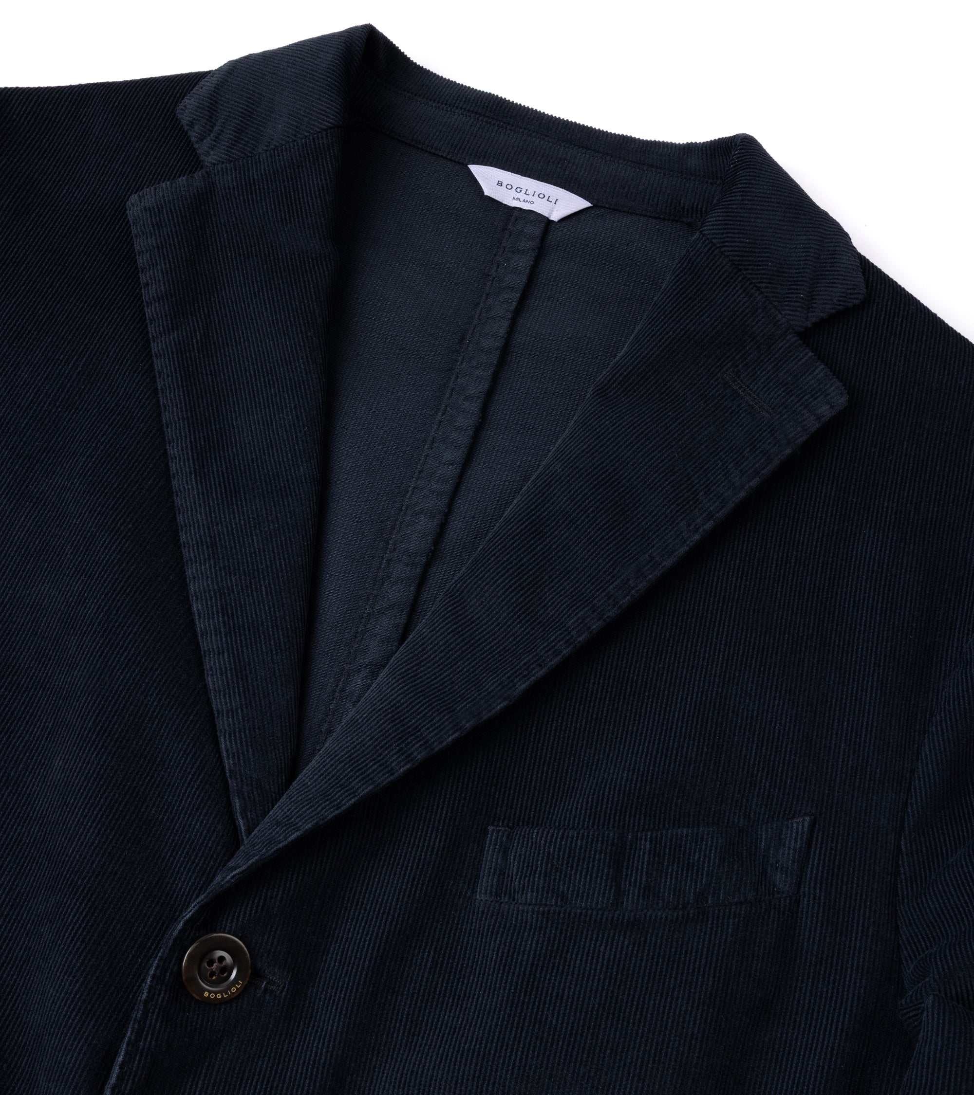 Close-up of a navy blue corduroy blazer jacket showing the collar, button, and chest pocket against a white background.