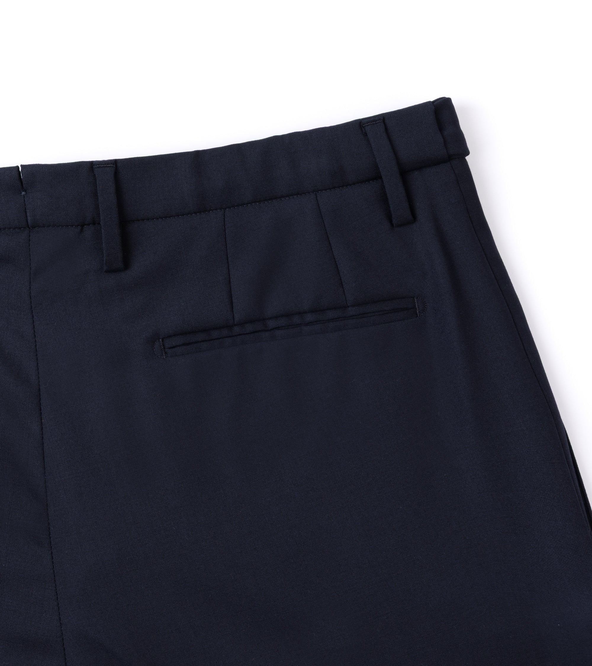 Close-up of dark navy trousers showing the waistband, belt loops and a rear welt pocket on a white background.