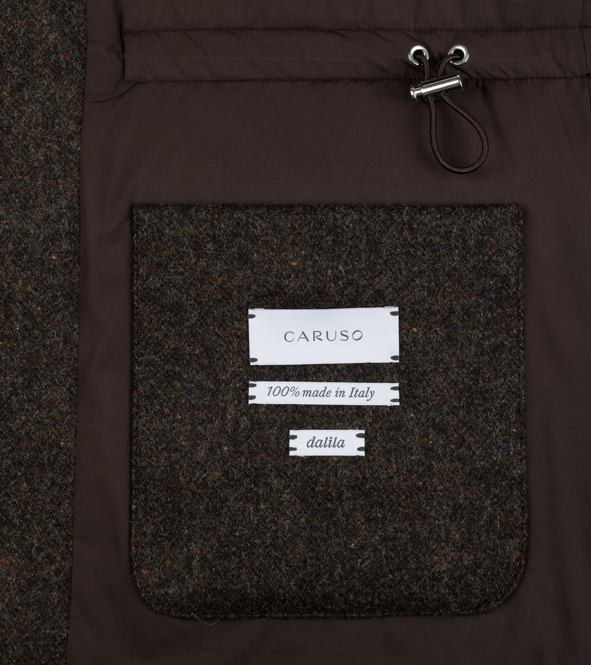 Close-up of the Caruso Shetland Wool Paddock Jacket in Dark Brown interior showing a large textured wool pocket with white brand label and fabric details.