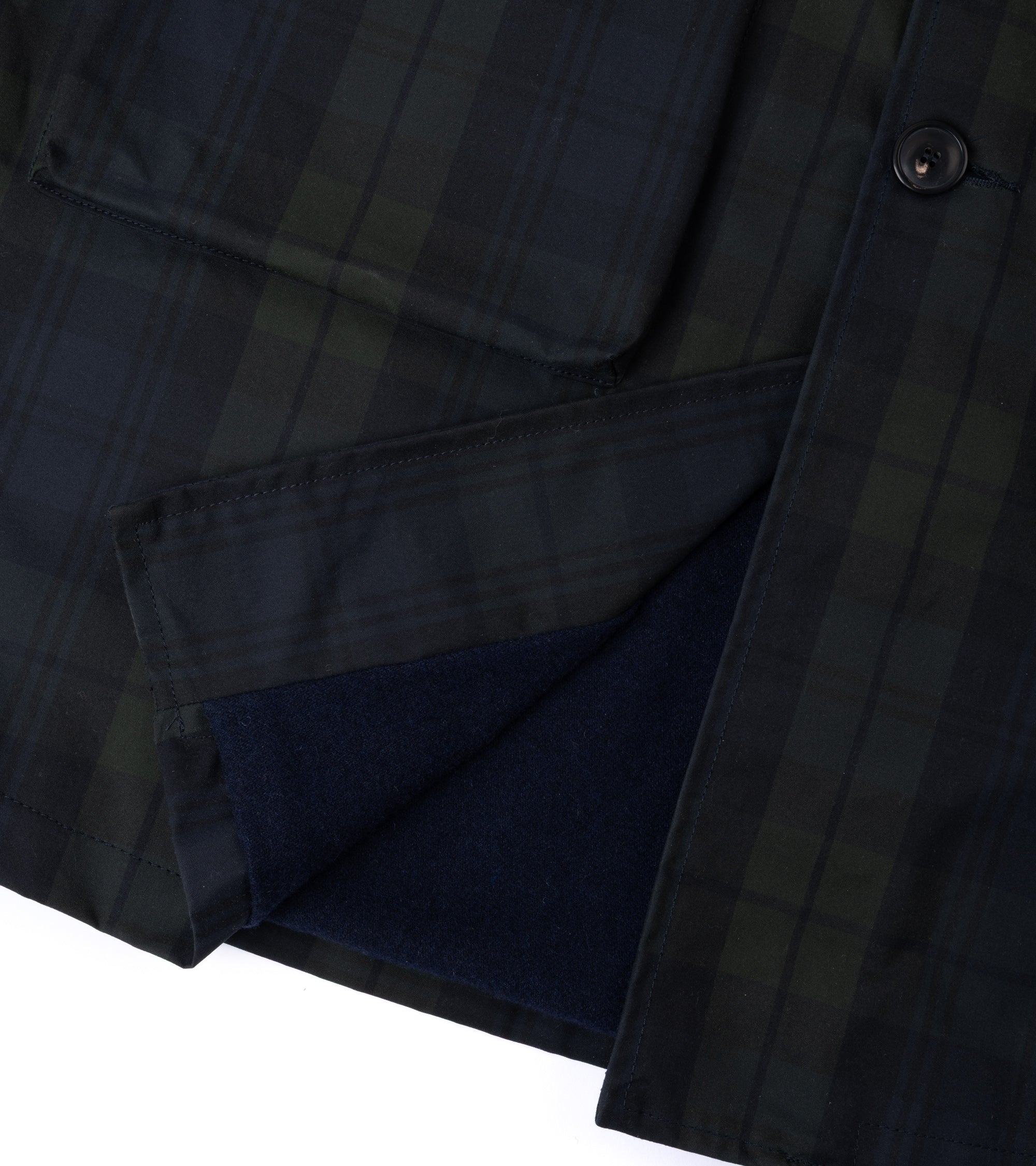 Waxed cotton trench coat in blackwatch, close up of the fabric texture and inner lining.