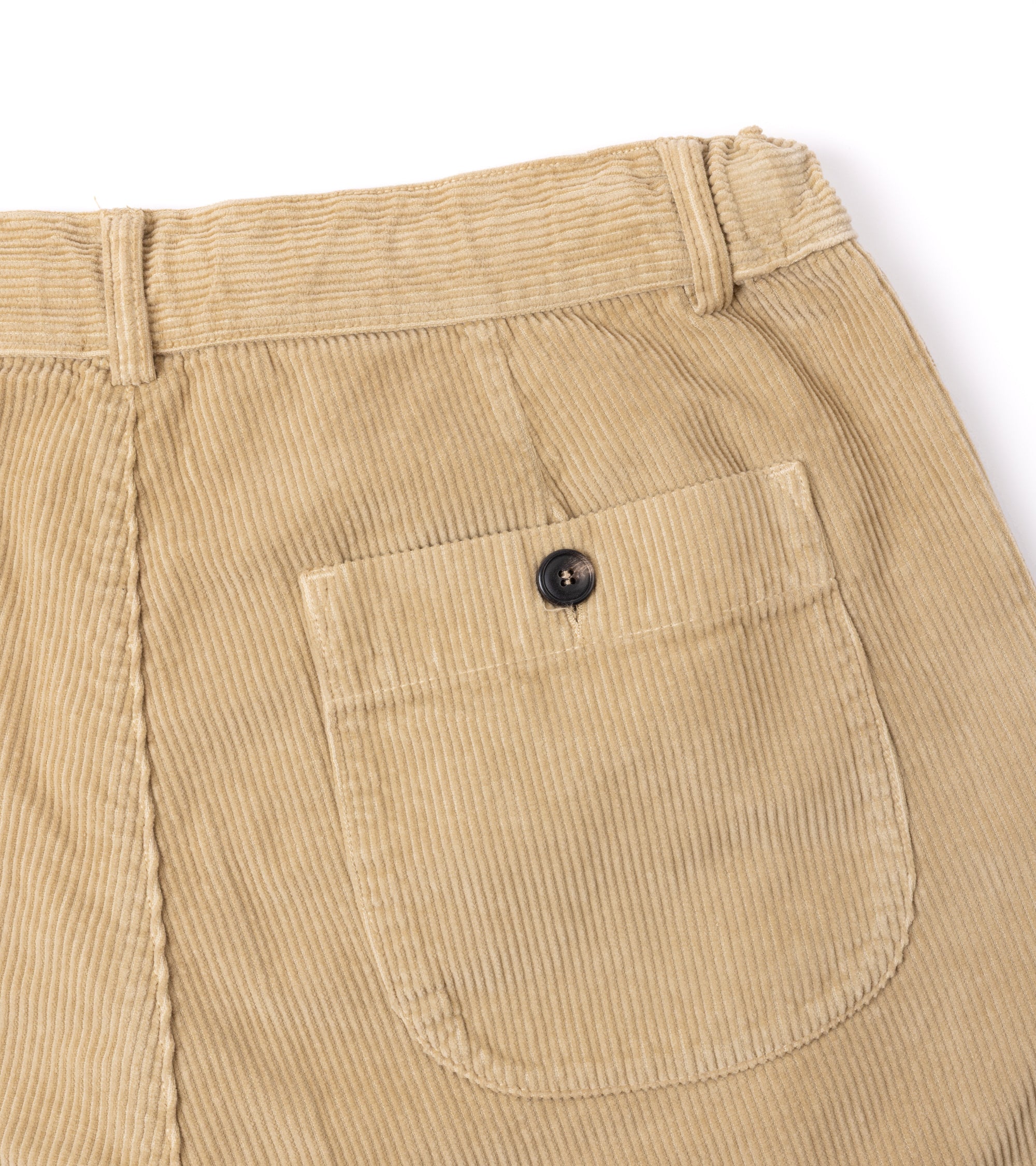 Close-up of the back waistband and pocket of beige corduroy pants, showing a single buttoned welt pocket and ribbed fabric texture against a white background.