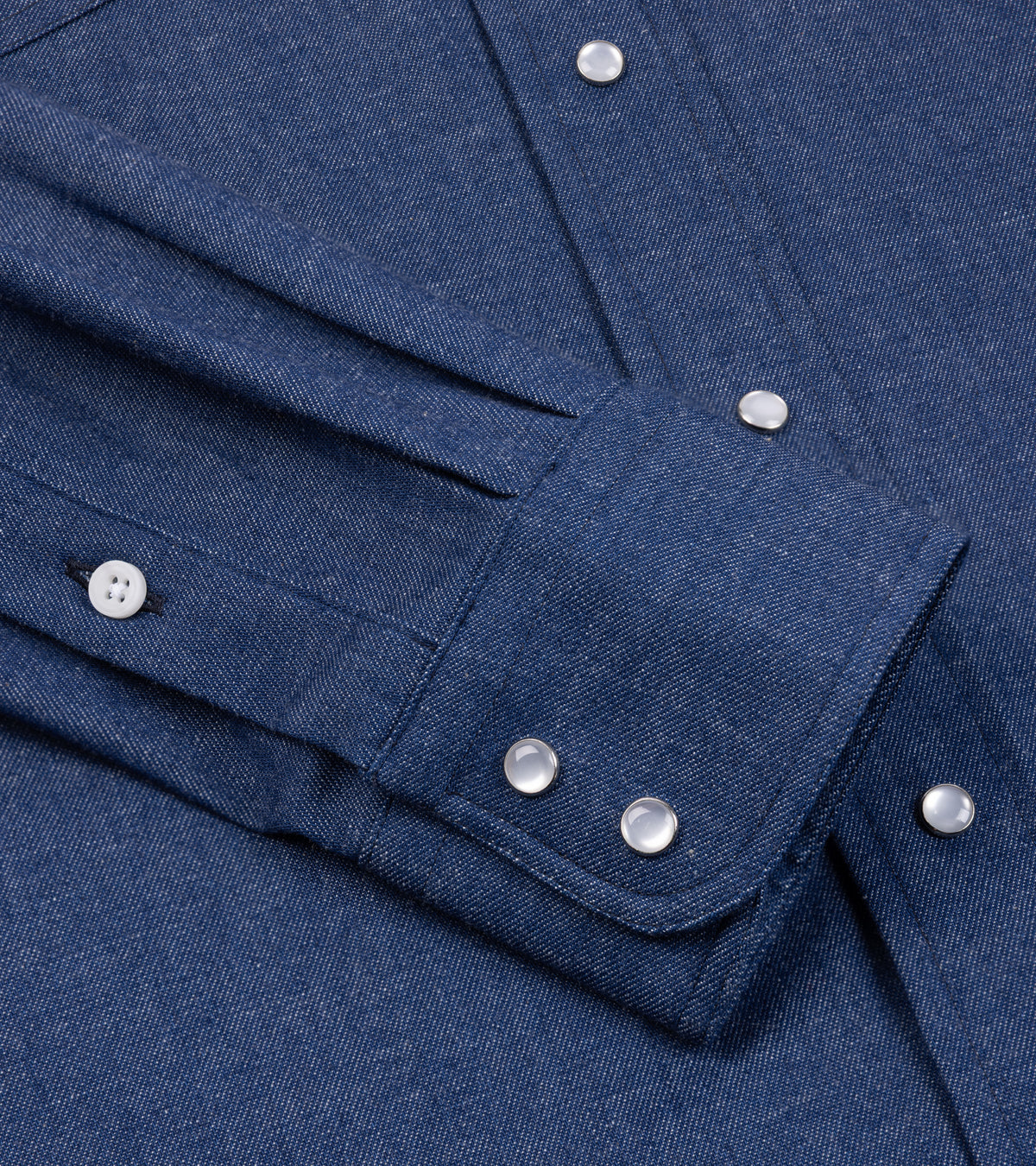 Close-up of the Gitman Vintage Denim Western Shirt in Light Blue showing the  cuff with western snap buttons and the fabric texture.
