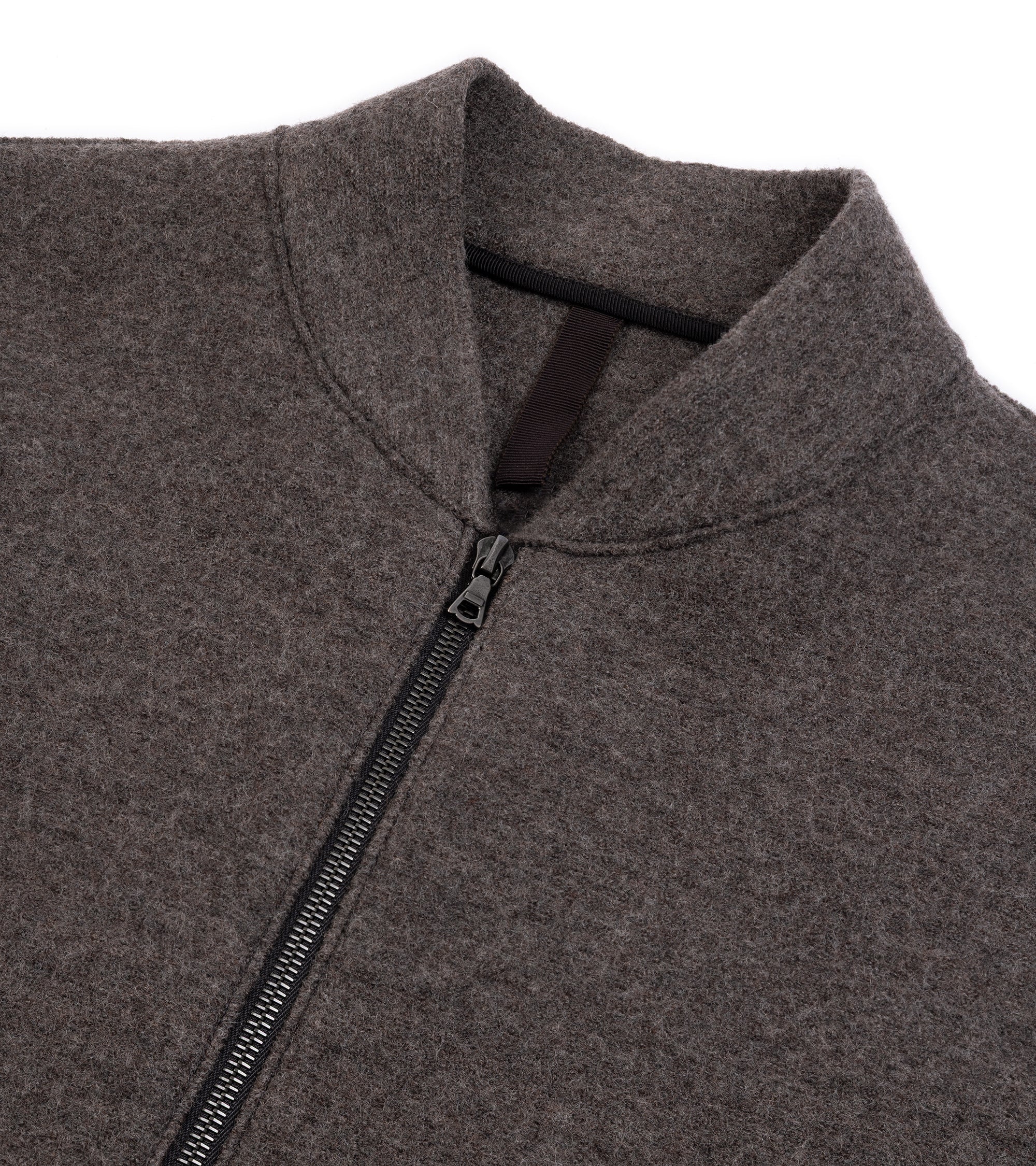 A close-up of a zip-up jacket featuring a high collar, a silver zipper.