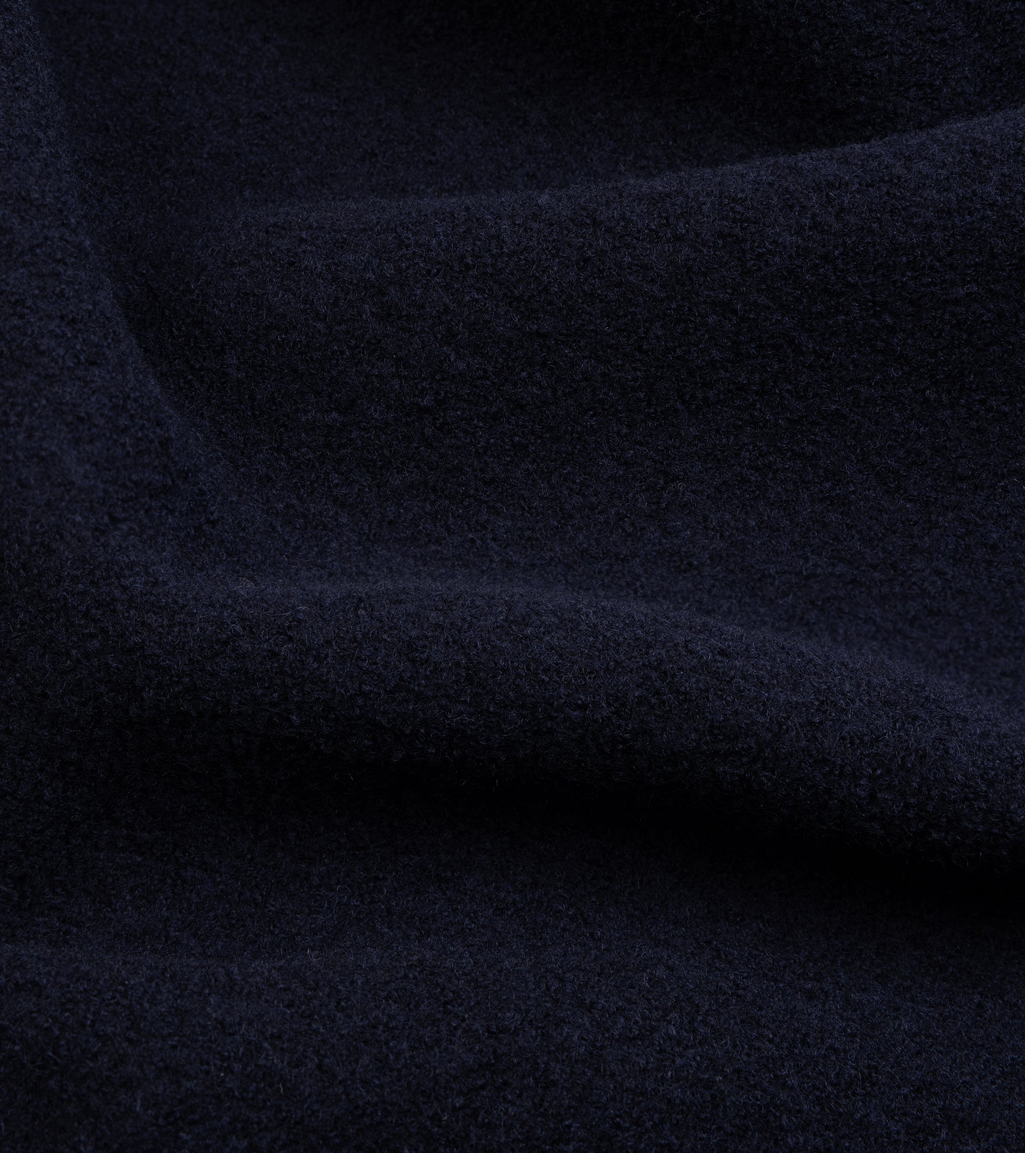 A close-up of dark navy blue textured fabric.