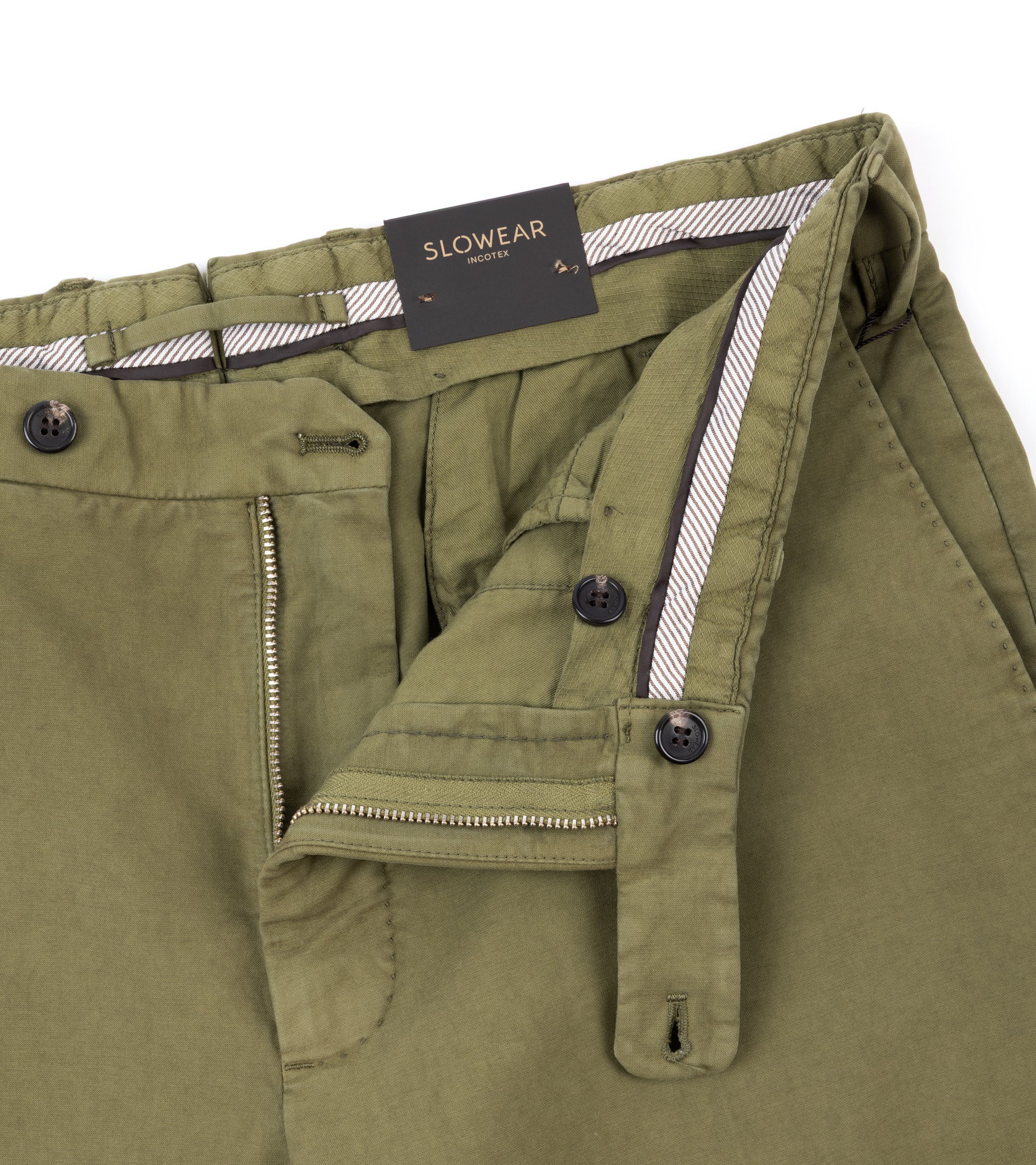 Close-up of olive green Slowear trousers showing the waistband, zipper and button details.