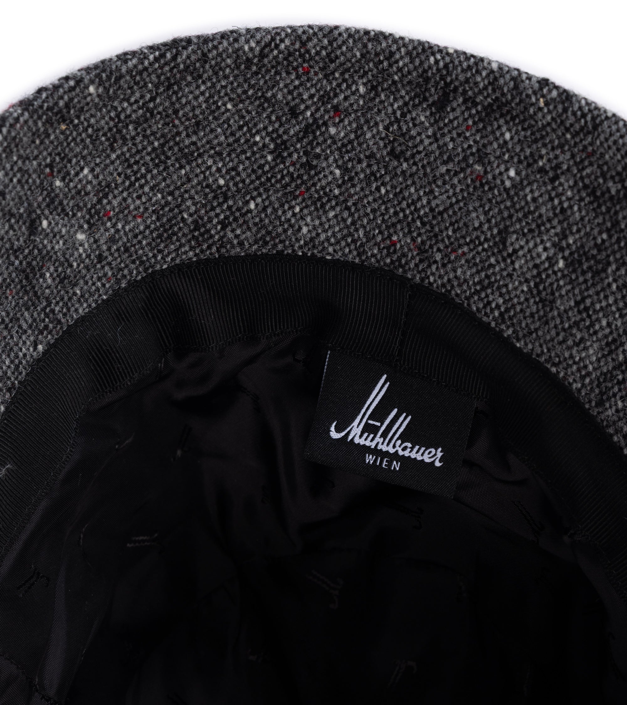 Close-up of the interior of a dark gray hat, showing the black fabric lining.