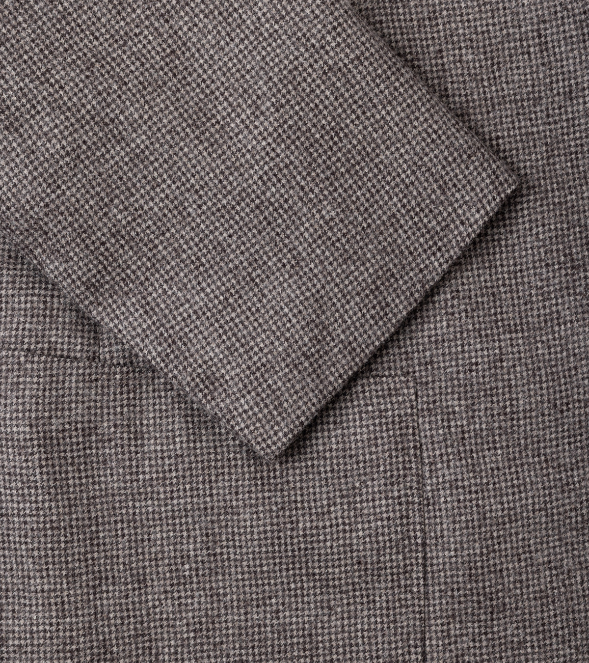 Close-up of a textured woven fabric in a grey brown color, showing the material detail and fold.
