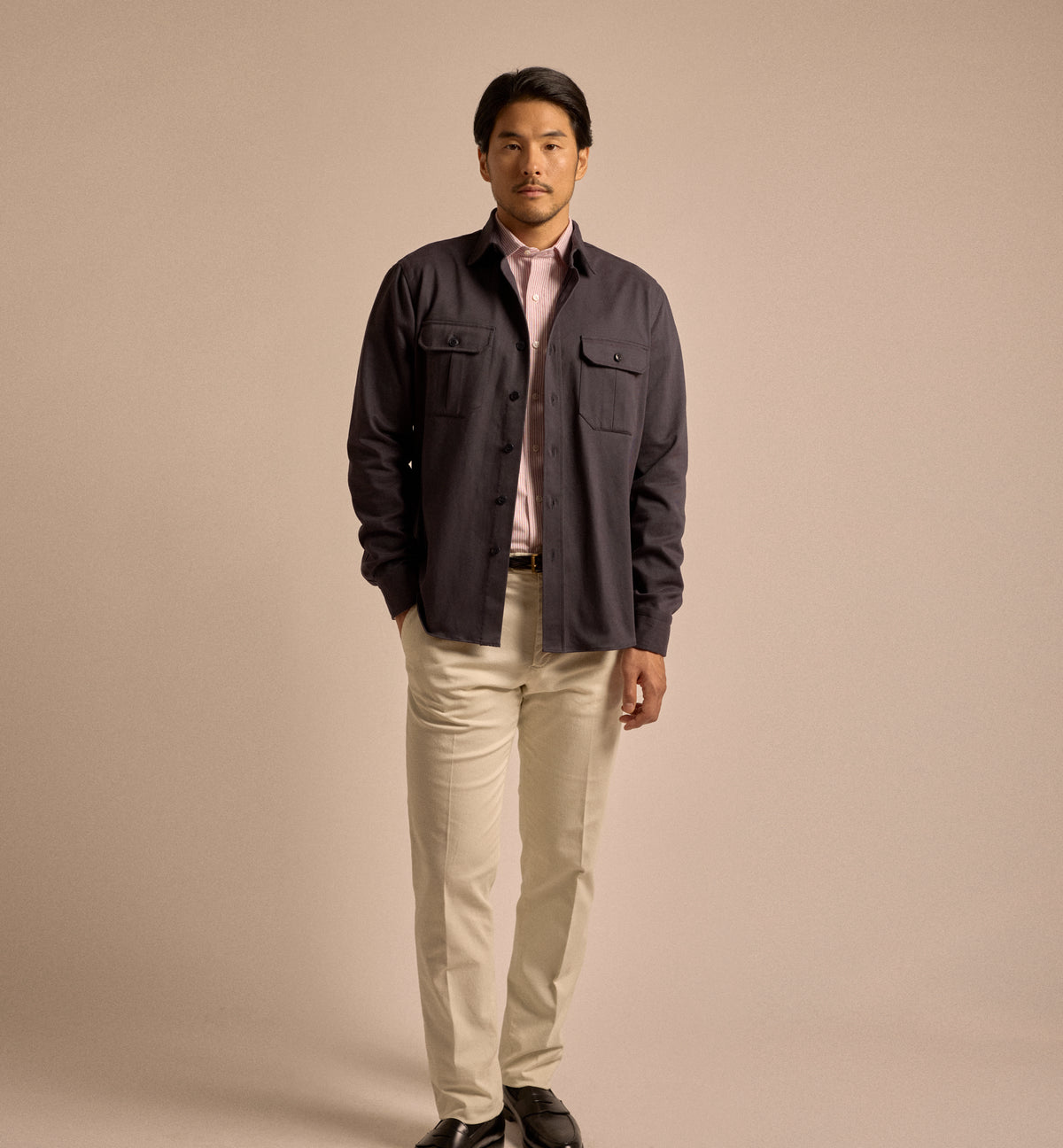 Model wearing Salvatore Piccolo Cotton Twill Military Shirt in navy. Styled here with a Salvatore Piccolo shirt in red and white stripe, Trunk Palmer trousers in sand and black leather loafers.